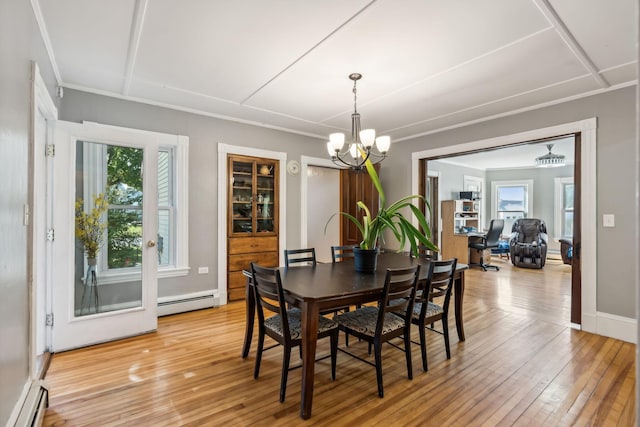 dining area featuring light wood-type flooring, a baseboard heating unit, baseboard heating, and a notable chandelier