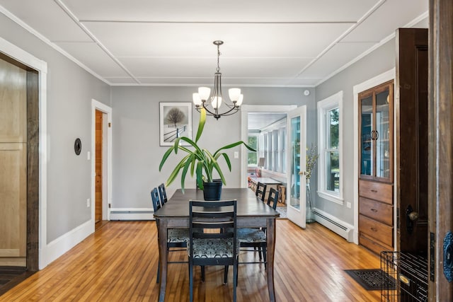 dining area featuring a baseboard radiator, light wood-style flooring, baseboards, baseboard heating, and an inviting chandelier