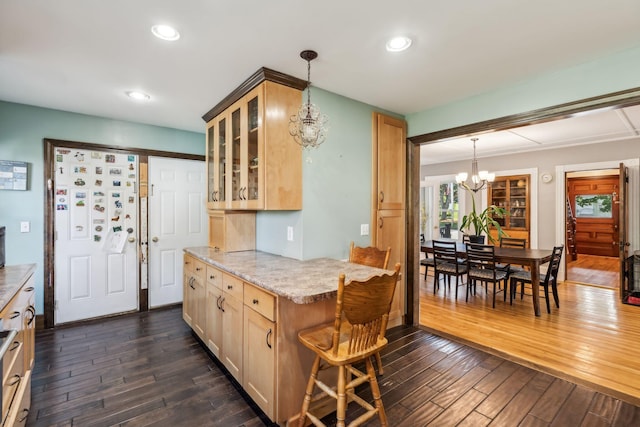 kitchen with glass insert cabinets, dark wood-style flooring, pendant lighting, and a chandelier