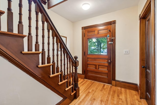 foyer featuring stairway, baseboards, and hardwood / wood-style floors