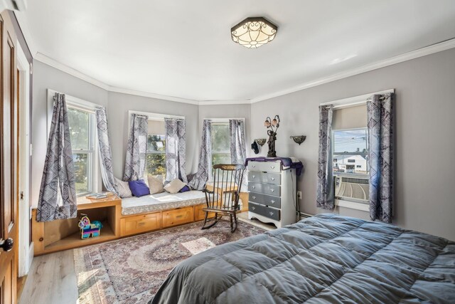 bedroom featuring cooling unit, ornamental molding, and wood finished floors