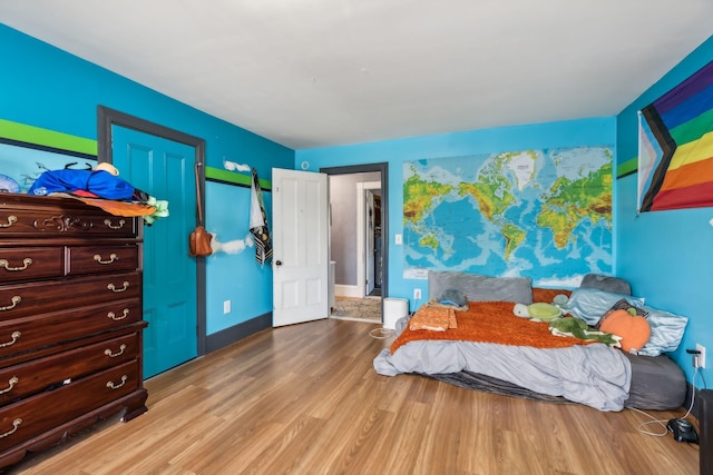 bedroom featuring wood finished floors and baseboards