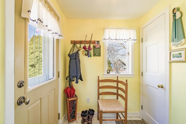 doorway with baseboards and tile patterned flooring