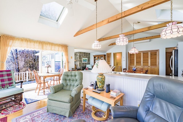 living area featuring vaulted ceiling with skylight and wood finished floors