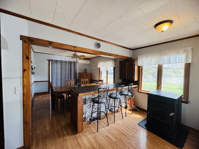 30 Washington St, Caribou, ME 04736 - kitchen with ornamental molding, light wood-style flooring, baseboards, a breakfast bar, and a ceiling fan