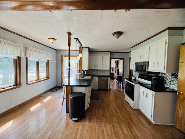 30 Washington St, Caribou, ME 04736 - kitchen with appliances with stainless steel finishes, a sink, dark countertops, dark wood-style flooring, and crown molding