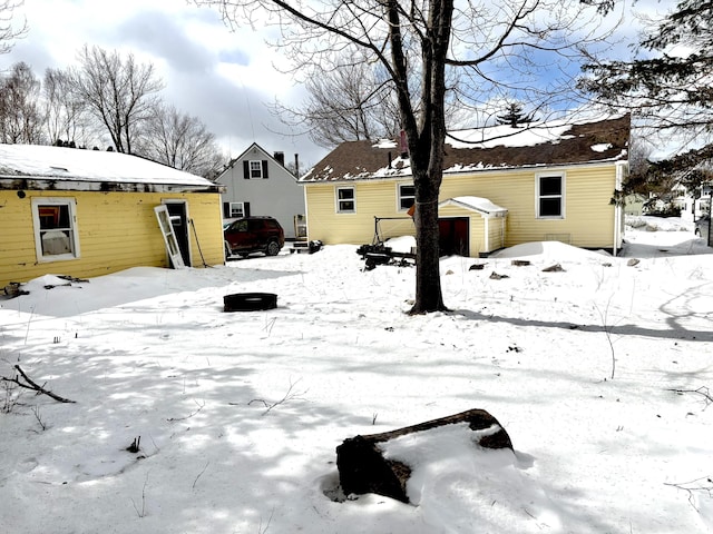 snowy yard featuring an outbuilding