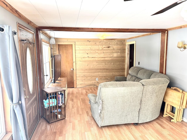 living room featuring light wood-type flooring and wooden walls