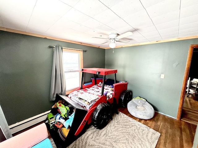 playroom with baseboard heating, wood finished floors, and baseboards