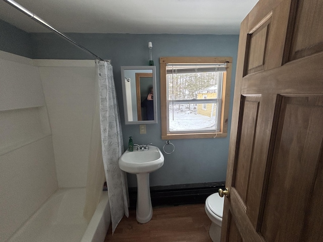 bathroom featuring shower / bath combo with shower curtain, baseboards, toilet, and wood finished floors