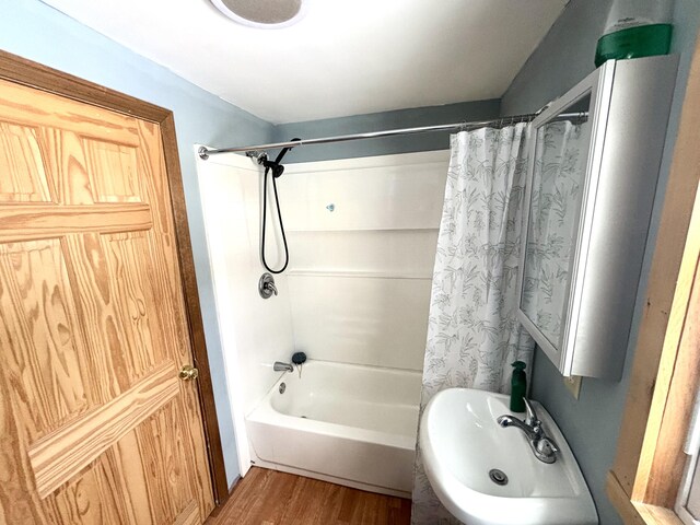 full bathroom featuring shower / tub combo, a sink, and wood finished floors