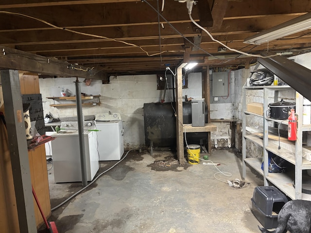 unfinished basement featuring heating fuel, electric panel, and washer and dryer