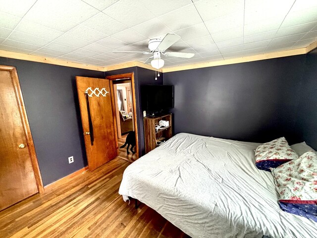 bedroom featuring baseboards, a ceiling fan, and wood finished floors