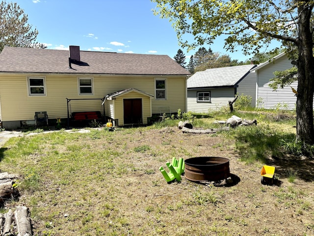 5 Grove St, Millinocket, ME 04462 - rear view of property featuring a fire pit, roof with shingles, and a chimney