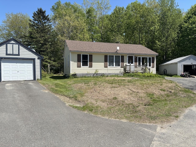 5 Grove St, Millinocket, ME 04462 - view of front facade featuring an outbuilding, covered porch, a garage, and a front lawn