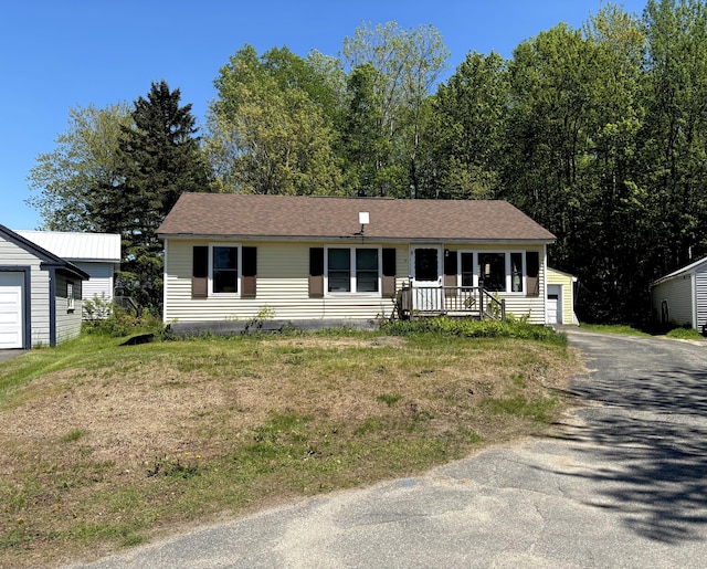 5 Grove St, Millinocket, ME 04462 - view of front facade featuring covered porch, a garage, and an outbuilding