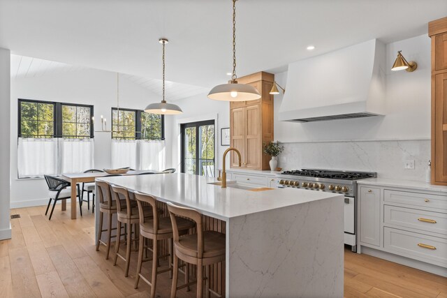 65 Sky Dr, Windham, ME 04062 - kitchen with stainless steel range, decorative backsplash, custom range hood, vaulted ceiling, and a sink