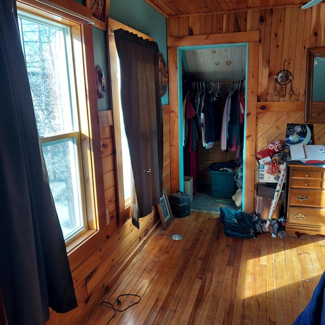 bedroom featuring a closet, wooden walls, and hardwood / wood-style floors