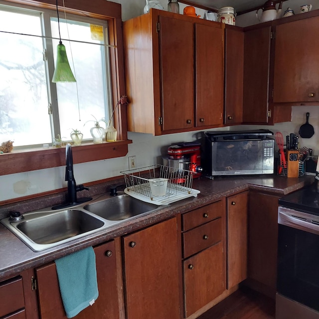 kitchen featuring dark countertops, stainless steel electric range, black microwave, and a sink