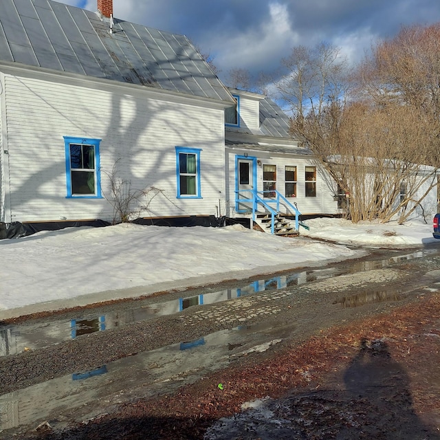 rear view of property featuring metal roof and a standing seam roof