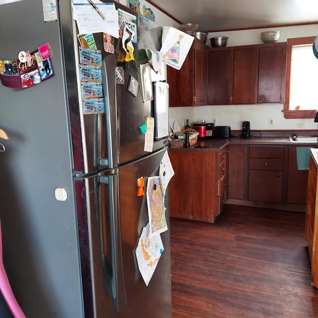 kitchen with dark countertops, freestanding refrigerator, and dark wood-style flooring