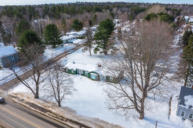 snowy aerial view featuring a forest view