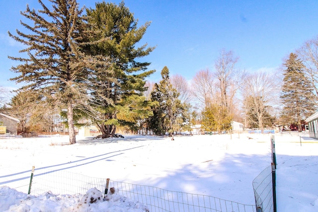 yard covered in snow with fence