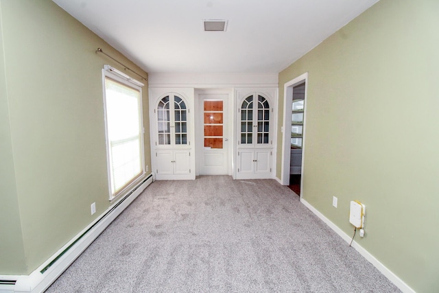 carpeted empty room featuring a baseboard radiator and baseboards