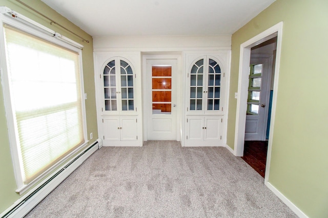 interior space featuring carpet floors, a baseboard radiator, and baseboards