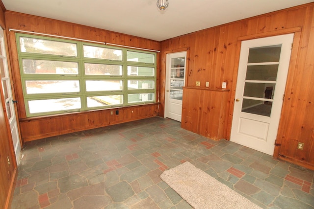 spare room featuring wood walls and stone finish floor