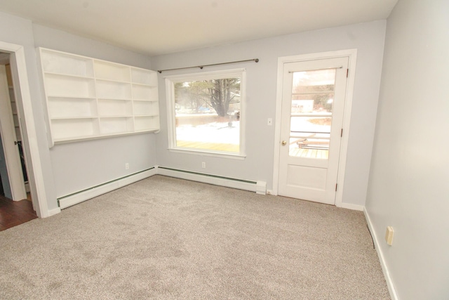 empty room with carpet floors, baseboard heating, and baseboards