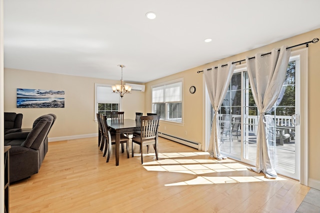 dining room featuring a wall unit AC, light wood-style floors, a baseboard radiator, baseboards, and a chandelier