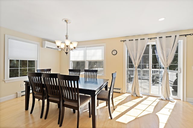 dining space featuring a notable chandelier, an AC wall unit, a baseboard heating unit, and light wood-style floors