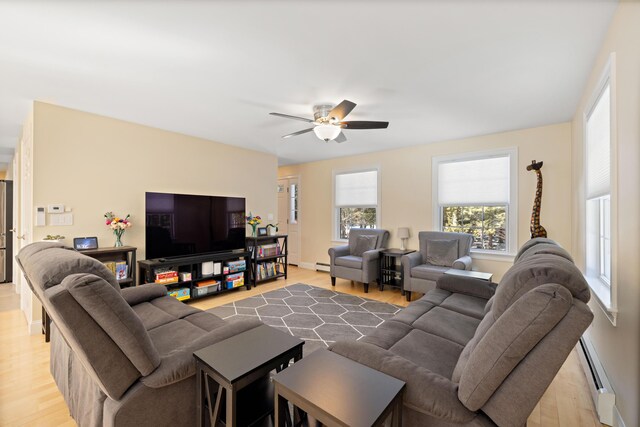 living room with a baseboard heating unit, a ceiling fan, and wood finished floors