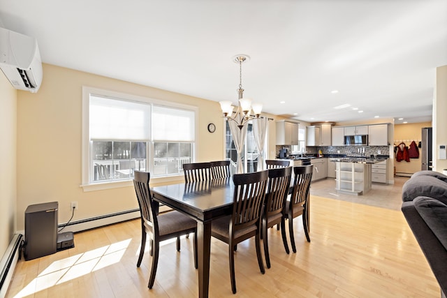 dining room featuring light wood finished floors, baseboard heating, an inviting chandelier, and a wall unit AC