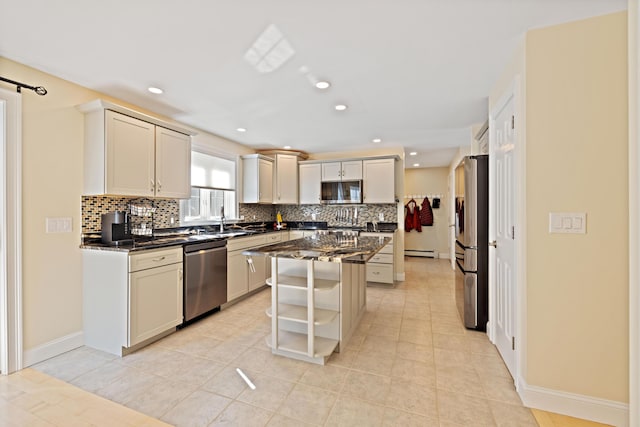 kitchen with a kitchen island, backsplash, stainless steel appliances, and a sink