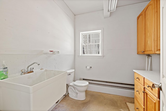 bathroom featuring a sink, a baseboard heating unit, toilet, and unfinished concrete floors