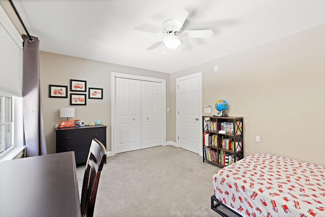 carpeted bedroom featuring a closet, baseboards, and a ceiling fan