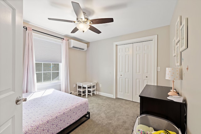 bedroom with baseboards, ceiling fan, an AC wall unit, a closet, and carpet flooring