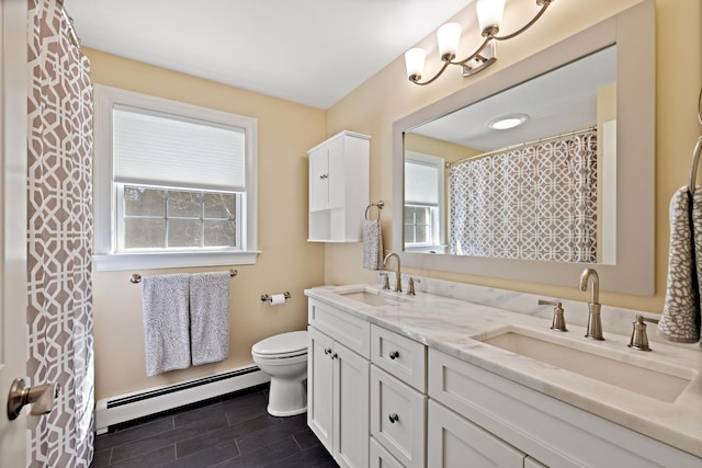 bathroom featuring double vanity, toilet, a baseboard radiator, and a sink