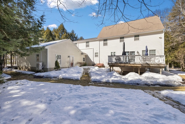 snow covered house with a wooden deck