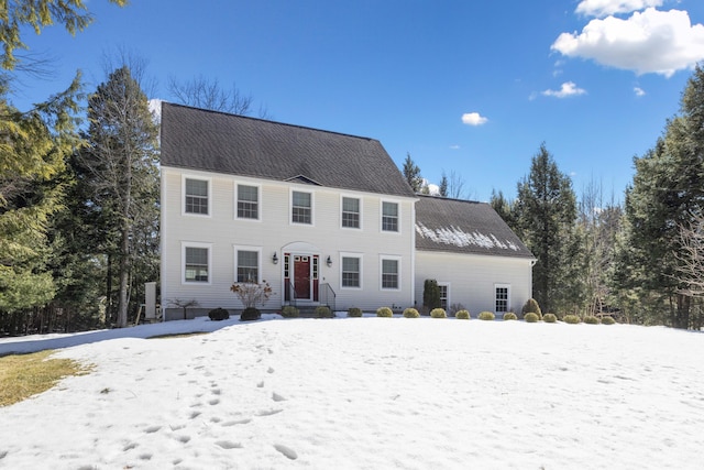 colonial-style house with roof with shingles