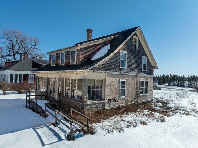 snow covered property featuring a chimney