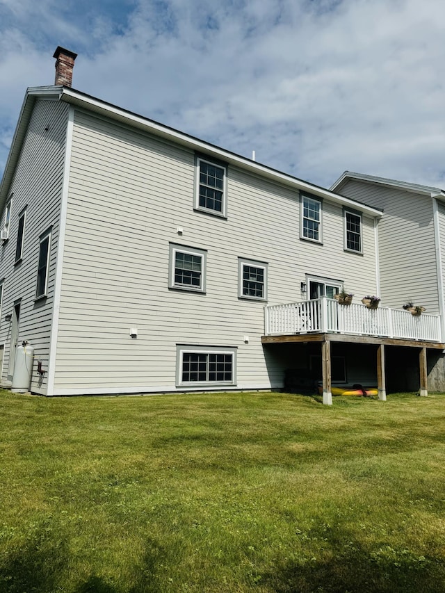 rear view of property with a yard and a chimney