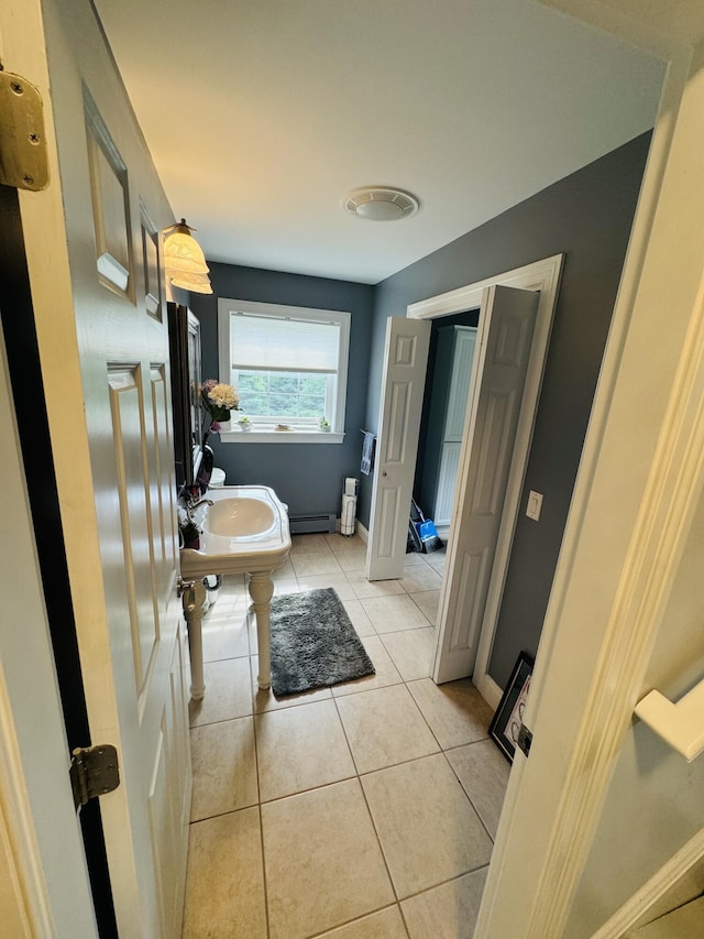 bathroom with baseboards, baseboard heating, and tile patterned floors