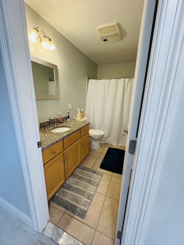 bathroom with vanity, toilet, and tile patterned floors