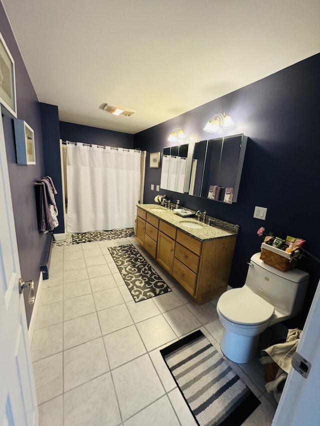 bathroom featuring double vanity, a shower with shower curtain, toilet, a sink, and tile patterned floors