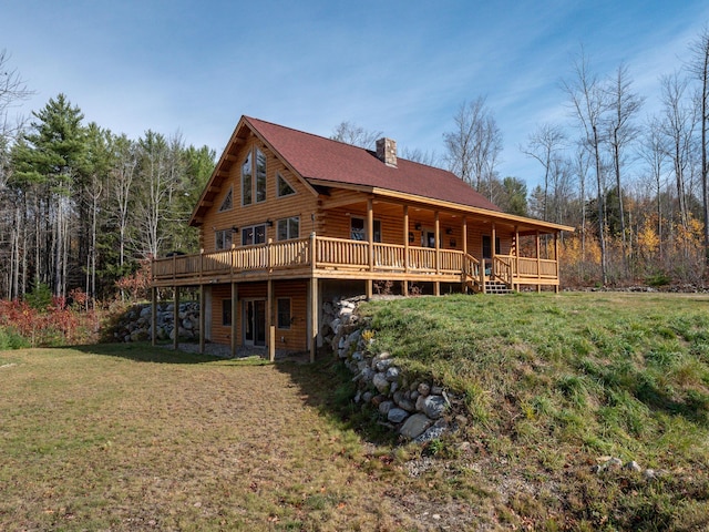 rear view of property featuring a deck, a yard, log exterior, and a chimney