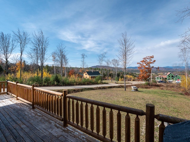 wooden deck with a lawn and a mountain view