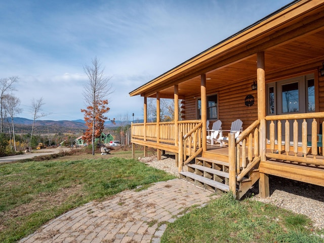 wooden deck featuring covered porch and a mountain view